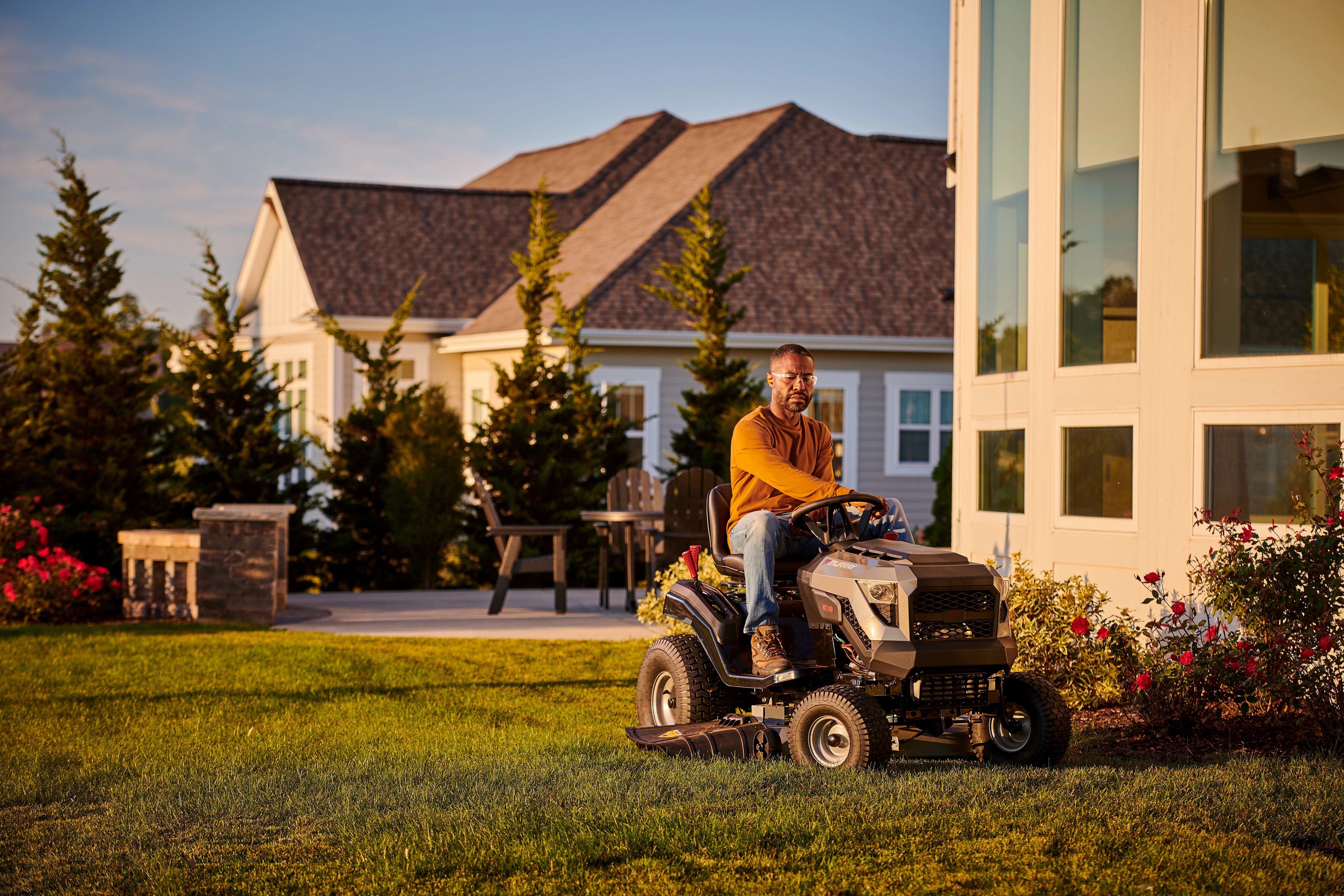 Man comfortably driving a Murray riding lawn mower powered by a Briggs & Stratton PXi V-Twin engine